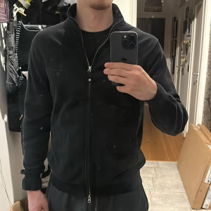 GANT Premium cotton kofta/tröja zip up  - Svart kofta från GANT i bomull med ribbad krage och muddar. Klassisk design med hel dragkedja framtill och diskret GANT-logga på bröstet. Perfekt för lager-på-lager och funkar året runt. Snygg och enkel att matcha med det mesta. M men passa oxå för S 