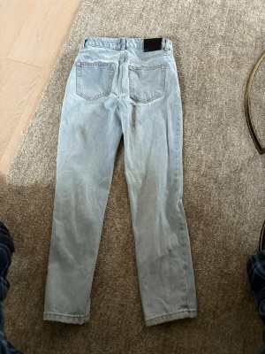 Ljusblå raka jeans från Acne Studios - Säljer ett par ljusblå jeans från Acne Studios med raka ben och klassisk femficksdesign. Jeansen har en snygg tvätt och är tillverkade i bomull. Perfekta för en avslappnad och trendig look.