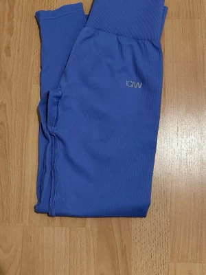 Blå seamless tights från ICANIWILL - Snygga blå seamless tights från ICANIWILL med hög midja och ribbad linning. Perfekta för gymmet eller löpning, tillverkade i stretchigt funktionsmaterial som andas. Diskret logga på höften och smal passform för en sportig look. Använda en gång