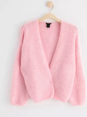 Ljusrosa stickad kofta från Lindex  - Mysig ljusrosa öppen stickad kofta från Lindex och lång ärm. Koftan har en fluffig, mjuk struktur och är något croppad i modellen. Perfekt att slänga över en topp för en chill look. 