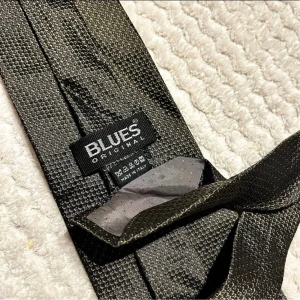 Svart silkeslips Blues Original - Stilren svart slips från Blues Original, tillverkad i Italien av 100% silke. Slipsen har en diskret textur och elegant glans som ger en exklusiv känsla till din outfit. Perfekt för dig som vill ha en klassisk accessoar med lyxig touch.