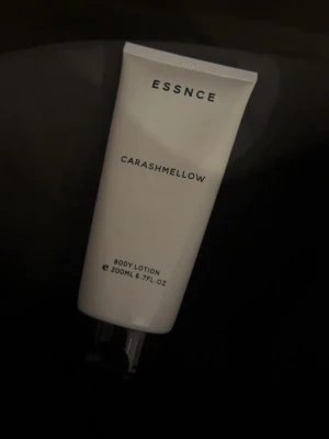 Essnce Carashmellow Body Lotion - Essnce Carashmellow Body Lotion i en stilren vit tub på 200 ml. Lotionen har en enkel och modern design med svart text och praktiskt snäpplock. Perfekt för dig som vill återfukta huden med en fräsch och mjuk känsla.