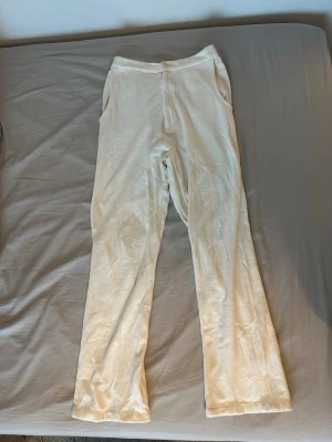 Djerf Avenue - Vita mjukisbyxor - Säljer ett par vita mjukisbyxor i mjuk velour med raka ben och resår i midjan. Byxorna har fickor på sidorna och en avslappnad passform som är perfekt för chill dagar. Perfekt för dig som gillar en clean och enkel stil.