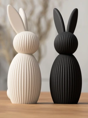 Dekorativa påskkaniner i svart och vitt - Två stilrena prydnadskaniner i svart och vitt med räfflad yta. Kaninerna har en modern, minimalistisk design och är tillverkade i ett matt material. 