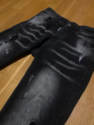 Svarta Dsquared2 jeans  - Säljer ett par feta slitna Dsquared2, svarta.  Jeansen passar någon som är 170-175cm lång. Pris: 299kr men går att diskuteras. Skick:7/10 eftersom det har en blå fläck vid gylfen. Skickas inom 24 timmar efter köp.