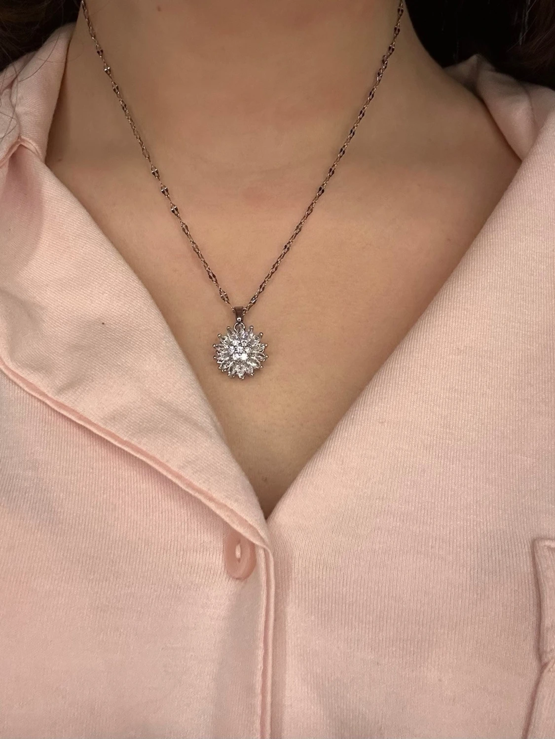 Silverfärgat halsband med blomma som kan snurra 