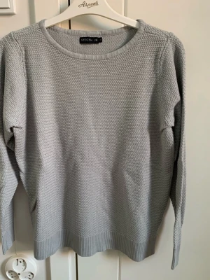 Klädpaket 3 tröjor stl S - Ljusgrå stickad tröja från STOCKH LM med rund halsringning och diskret strukturmönster. Tröjan har långa ärmar och ribbade muddar vid nederkant och ärmslut. Perfekt för lager-på-lager och enkel att matcha med jeans eller kjol.