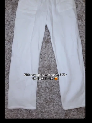Vita mjukisbyxor med raka ben - Säljer ett par vita mjukisbyxor med raka ben och resår i midjan. Byxorna har två bakfickor och är gjorda i ett mjukt och bekvämt material, perfekt för chill dagar. Snygg och enkel design som passar till det mesta.