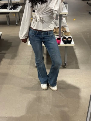 Blå bootcut jeans med låg midja - Snygga blå bootcut jeans med låg midja och klassisk femficksdesign. Jeansen köptes i höstas och är i väldigt bra skick. Säljer då de börjar bli för korta på mig.