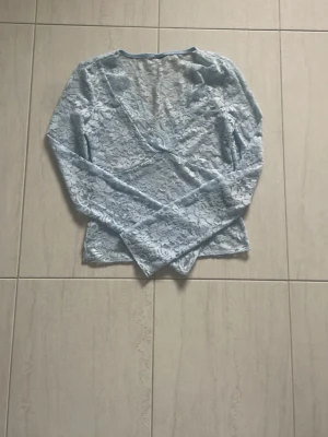 Gina tricot - V ringad ljusblå blom spetstopp från Gina tricot. Lappen är bort klippen!