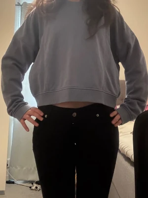 Blå croppad sweater - Säljer en blå croppad sweater med oversized passform och breda ärmar. Tröjan har ribbade muddar vid ärmslut och nederkant. Perfekt för en chill och avslappnad stil. Materialet känns mjukt och bekvämt mot huden. Köpte den i Spanien för 3 år sen, har inte kommit till användning