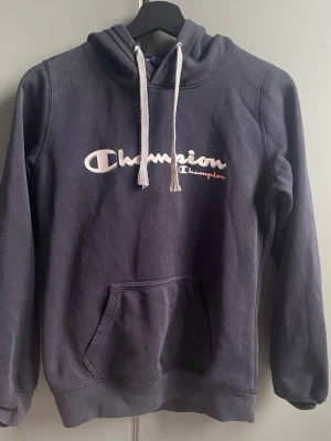 Hoodie - Snygg mörkblå hoodie från Champion. Banden är hyfsat slitna🩷