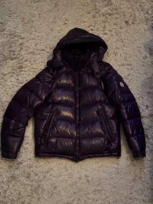 Moncler Maya size 3  - Hej, säljer nu min Moncler Maya i en rare lila kulör, Jackan är i storlek 3, jag är 178, 75kg och bär oftast M kläder. Jackan är i bra skick men har lite vattenfläckar på sig. Vid mer bilder/information hojta gärna till! Mvh W.V