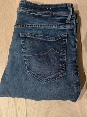 Mörkblå Jacob cohen  - Snygga mörkblå jeans med slim jeans och klassiska bakfickor. Jeansen har en enkel design med kontrastsömmar och är tillverkade i mjukt denimtyg. Perfekta för en avslappnad och trendig look.