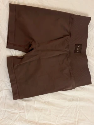 Bruna höga träningsshorts från VOX - Säljer par gråa scrunch shorts från VOX activewear. Dessa är så snygga! Det finns inga andra shorts som får ens rumpa att se så bra ut (min ser inte så bra ut egentligen som på första bilden hehe). Tyvärr har jag slutat använda shorts och använder mest leggings, så säljer för att de inte kommer till användning längre. De är lika defynes modell som heter dynamic! Säljer även i andra färger. Som sagt dessa var verkligen mina favoriter, det är därför jag genom åren har köpt så många😍