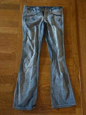 Ljusblå bootcut Only-jeans - Säljer ett par ljusblå Only jeans med bootcut-modell och coola detaljer på bakfickorna. Midjemåttet är 37 cm och innerbenslängden är 73 cm.