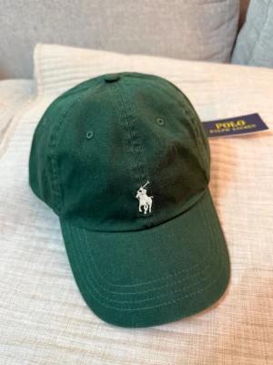 Grön keps från Polo Ralph Lauren - Snygg grön keps från Polo Ralph Lauren med klassisk vit broderad logga