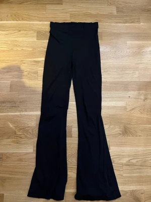 Svarta ribbade utsvängda leggings XS - Säljer ett par svarta ribbade leggings från 157 i storlek XS. De har hög midja och utsvängda ben. Materialet är stretchigt och bekvämt.