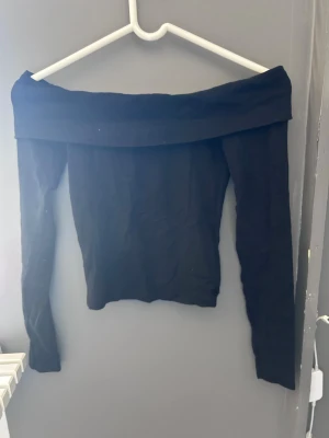 Svart offshoulder topp - Svart off-shoulder långärmad tröja.