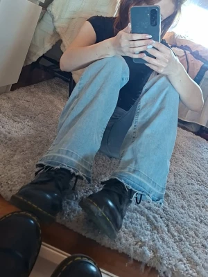 Svarta Dr. Martens kängor - Säljer ett par klassiska svarta Dr. Martens kängor i läder med den ikoniska gula sömmen runt sulan. Modellen har snörning framtill och en chunky sula..