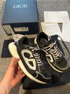 Svarta dior b30 - Svarta dior b30 med box och tillbehör. Skorna är använda men ändå i bra skick och har mycket kvar att ge! Pris kan diskuteras vid snabb affär! Storlek 45