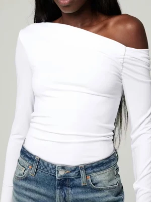 Vit off shoulder topp  - Säljer en vit topp med en axelrem från Bik Bok med etiketter på! Det finns en fläck på änden av ena ärmen och en sminkliknande fläck nära det intilliggande området, men de kanske kan tas bort manuellt med diskmedel. Original pris: 299