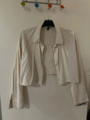 Jeansjacka  - Säljer en croppad beige jeansjacka/skjorta med långa ärmar och krage. Perfekt att styla över ett linne eller t-shirt. I storlek L men passar mig som vanligtvis har S. Från H&M