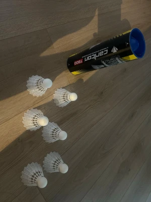 Fjäderbollar Carlton 7800 - Säljer ett rör med Carlton 7800 fjäderbollar för badminton. Fjäderbollarna är vita och gjorda i plast med rund topp. Perfekt för dig som vill spela badminton med vänner eller träna teknik.