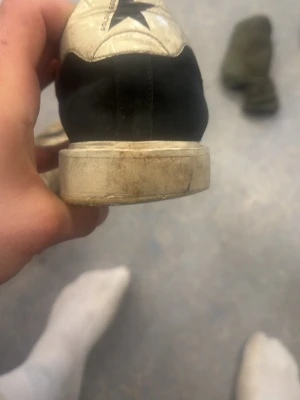 Svarta och vita sneakers med stjärna - Snygga sneakers från Converse i svart och vitt med en tydlig stjärndetalj på sidan. Skon har en klassisk låg profil och en vit sula. Perfekta för dig som gillar en stilren och tidlös look.