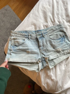 Ljusblå jeansshorts  - Säljer ett par ljusblå jeansshorts då de är för stora för mig, perfekta till en varm sommar dag!