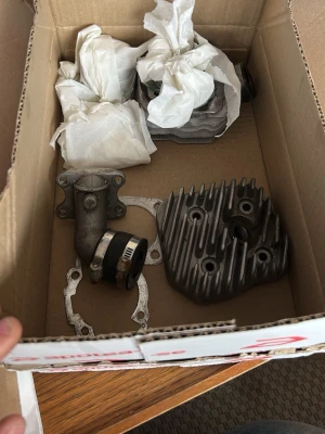 70cc insug o membran till viva - Säljer ett kit med motordelar till moped eller scooter. Innehåller cylinder, topplock, insugningsrör och packningar. Delarna är av metall och har en grå och silverfärgad yta. Perfekt för dig som gillar att meka eller behöver reservdelar till din tvåhjuling.