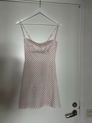 Ljusrosa/beige prickig kort klänning - Supersöt ljusrosa/beige kort klänning med mörkbruna prickar och tunna axelband som går att anpassa💕Klänningen har en figurnära passform upptill och lätt utsvängd kjol perfekt i sommar💕aldrig använd 
