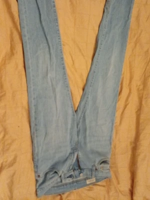 Ljusblå 511 jeans, Levi's - Ljusblå jeans från Levi's med klassisk rak passform och femficksdesign. Jeansen har en enkel look med Levi's ikoniska röda etikett på bakfickan. Tillverkade i denim av bomull, perfekta för en avslappnad stil. Även en liten fläck på insidan av höger ben men det syns eller märks aldrig av, annnars inget slitage.