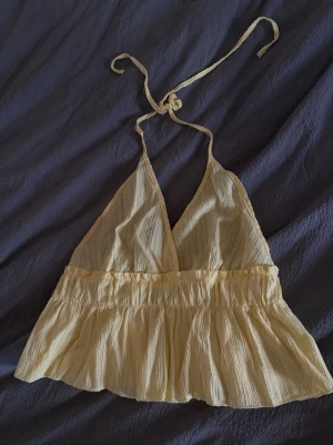 Gul topp med öppen rygg - Gul halterneck topp med öppen rygg, storlek S tror jag. Använd men i mycket bra skick! 