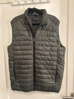 Olivgrön väst  - Säljer denna olivgröna tunna dunväst från märket On our Terms. Nypris ligger på 599kr, använd fåtal gånger, inga defekter. Pris går att diskutera 