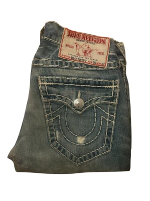 True Religion Jeans Billy Super T - True Religion Jeans, Billy, bootcut / flare. Storlek 30 i mycket bra skick, förutom en reperation i grenen. Midja 41cm, 101cm längd, 77cm innerben längd och 22cm ben öppning. 📲