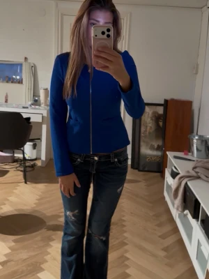 Kornblå figursydd jacka med dragkedja - Snygg kornblå jacka med figursydd passform och hel dragkedja framtill. Jackan har långa ärmar och en stilren, minimalistisk design utan synliga fickor eller detaljer. Perfekt för dig som gillar en enkel men trendig look.