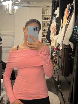 ZARA rosa offshoulder topp  - Trendig ljusrosa offshoulder topp med lång ärm och tight passform från ZARA. Perfekt för dig som gillar en stilren och feminin look. Tunn och stretchig, passar snyggt till både jeans och kjol. Den är köpt för 300 kr och är helt oanvänd 