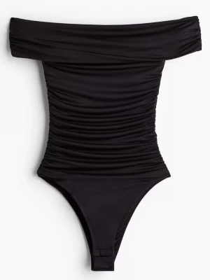 Svart off shoulder body - Snygg svart off shoulder body med rynkade detaljer längs hela kroppen. Tight passform och bred urringning som sitter snyggt över axlarna. Perfekt att styla med jeans eller kjol för en trendig look. Materialet känns stretchigt och följsamt.