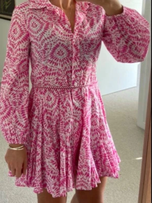 Rosa,vit kortklänning  - Supersöt kortklänning i rosa och vitt , knappar framtill och ett smalt knytband i midjan. 