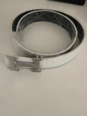 Vitt bälte med silverfärgat H-spänne - Snyggt vitt bälte med ett stilrent, silverfärgat H-format spänne. Bältet har en clean look och passar perfekt till jeans eller byxor för att lyfta din outfit. Tillverkat i slätt material med en modern känsla.