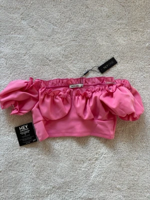 Rosa offshoulder topp från NLY One - Trendig rosa offshoulder topp från NLY One med puffiga ärmar och croppad passform. 