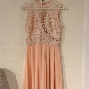Ljusrosa balklänning med spets - Superfin ljusrosa balklänning med vacker spets upptill och transparent vid halsen. 💘 Perfekt för bal! Använd 2 ggr, lite sliten längst ner. 