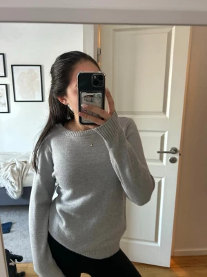 Ljusgrå stickad tröja med rund hals - Säljer en ljusgrå stickad tröja med rund hals och ribbade muddar. Tröjan är knappt använd och är i väldigt mjukt material❤️❤️✨💗🫶🥰🥰