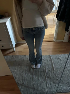 Joey low Rise flare jeans - Säljer ett par ljusblå flare jeans med låg midja från True religion med klassiska fickor bak. Jeansen har en snygg tvätt och sitter tajt över låren men släpper ut vid vaden. Jeansen är i storlek 23. Är i bra skick men förekommer lite defekter. Finns en liten fläck på höger ben (bild 4), samt slitningar längst ner. Uppsydda och passar mig som är 163 cm ❤️❤️❤️