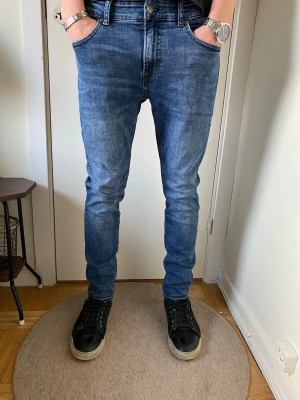 Only & Sons jeans Blåa - Snygga blå slim fit jeans med klassisk femficksdesign och normal midja. Jeansen har en lätt tvättad look och smal passform hela vägen ner. Perfekta för en trendig och avslappnad stil. Otroligt bra skick. | Nypris ~899kr säljer för 149kr | Står ingen storlek på dem men de är 42 cm i midjan och 99 cm långa 🙌