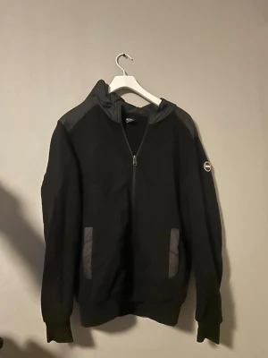 Colmar svart cardigan med luva M – fint skick - Stilren svart cardigan från Colmar med luva. Skön och sportig modell.  Storlek: M Skick: mycket bra  Passar perfekt som lätt jacka eller mellanlager.  Kan skickas eller mötas i Göteborg.