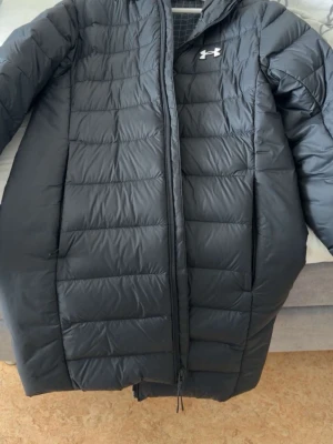 Under Armour parka - Lång jacka, nyskick, köpt för 2700kr på jd  i stockholm i november. Nästan aldrig använd. Passar både kön. Vääldig mörk ton av blå i färgen nästan som svart. Skön att ha på sig.