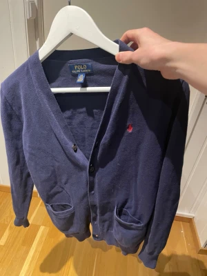 Mörklblå Ralph lauren cardigan xs/xxs - Ralph lauren cardigan i storlek LG 14-16. Passar dig som är mellan 155 och 165. Bra skick. Riktigt najs passform. Jag är 170 på bilden. Priset går att diskutera och ingen fråga är dålig!