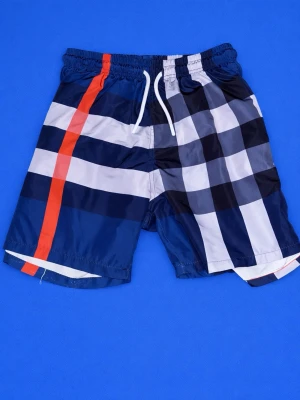 Rutiga badbyxor från Burberry - Säljer ett par snygga badbyxor från Burberry med klassiskt rutmönster i marinblått, vitt och svart samt en orange rand. De har resår i midjan och vita dragsnören. Materialet är snabbtorkande och perfekt för stranden eller poolen.